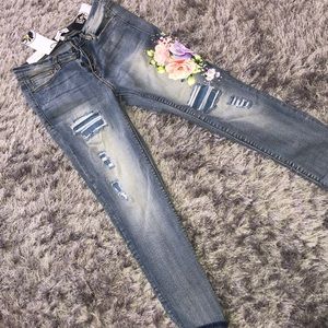 Ripped blue jeans with flowers and beadprint